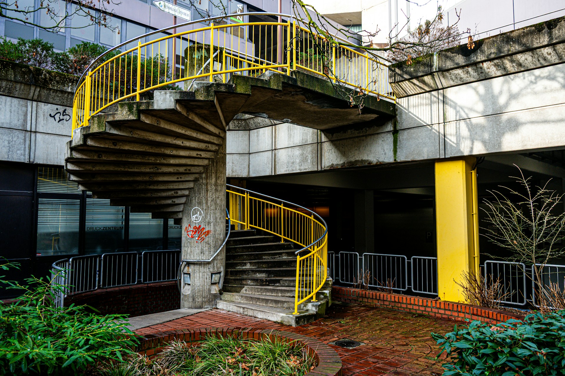 A concrete spiral staircase with yellow railings